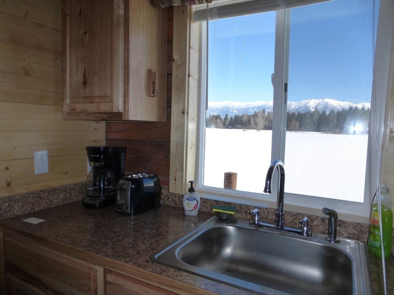 Sperry cabin kitchen overlooking mountains through window.